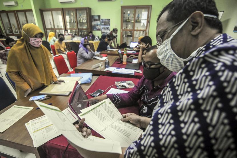 Petugas melayani orang tua siswa di posko Penerimaan Peserta Didik Baru (PPDB) di SMA Negeri 70, Jakarta.