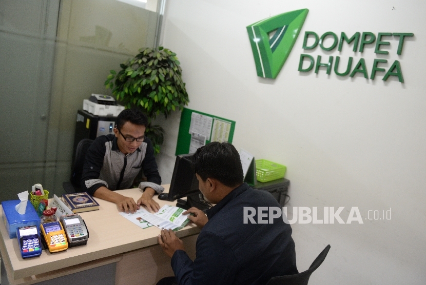 Petugas melayani pembayaran zakat di Gerai Dompet Dhuafa di Jakarta, Jumat (14/7). 