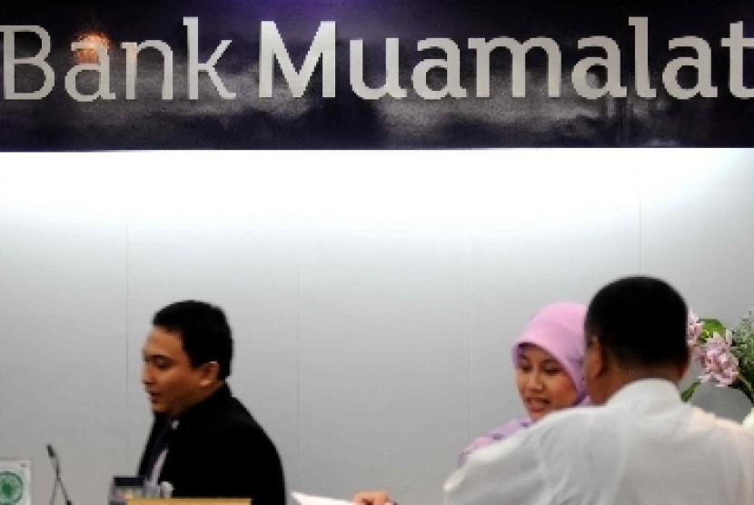 Petugas melayani transaksi nasabah di kantor layanan Bank Muamalat, Jakarta, Kamis (8/11).