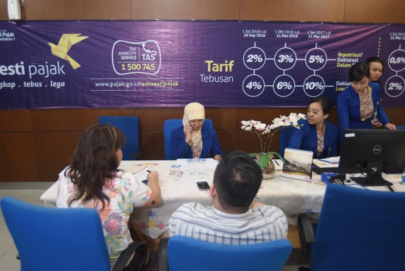 Petugas melayani wajib pajak untuk memperoleh informasi mengenai kebijakan amnesti pajak (tax amnesty) di Help Desk Kantor Wilayah Direktorat Jenderal Pajak I, Jakarta Selatan, Senin (19/9).
