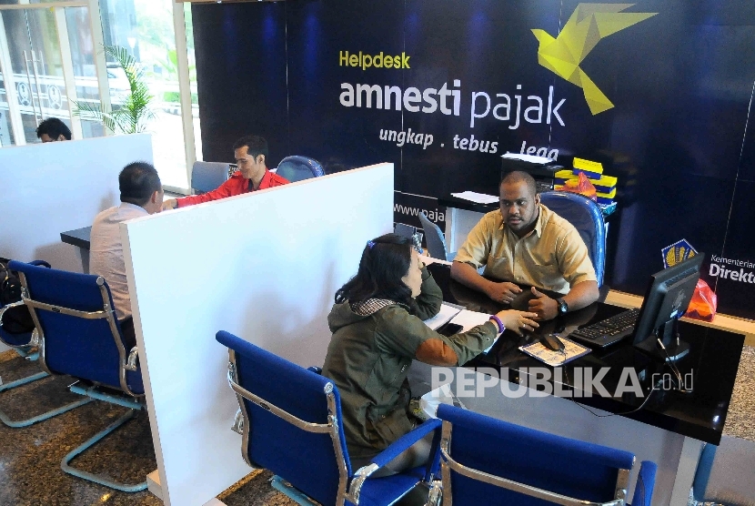 Petugas melayani wajib pajak yang ingin memperoleh informasi mengenai kebijakan amnesti pajak (tax amnesty) di Help Desk, di Gedung Direktorat Jenderal Pajak, Jakarta Pusat, Kamis (8/12).