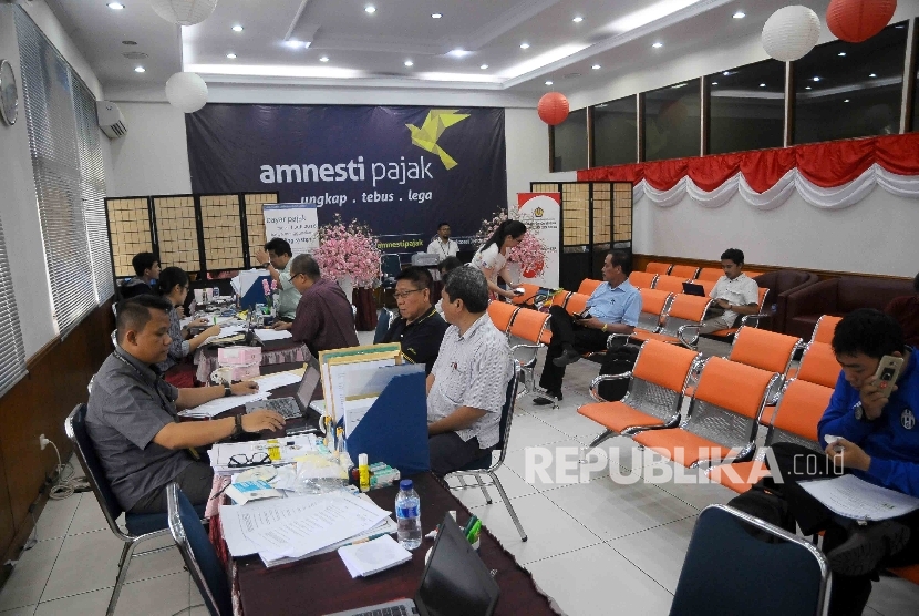 Petugas melayani wajib pajak yang mengikuti program pengampunan pajak (tax amnesty) di Kantor Pelayanan Pajak Tabah Abang, Jakarta Pusat, Kamis (29/12).