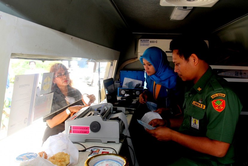 Petugas melayani warga untuk membayar Pajak Bumi dan Bangunan (PBB) di Jalan Juanda, Kota Bogor, Jawa Barat, Senin (14/3).