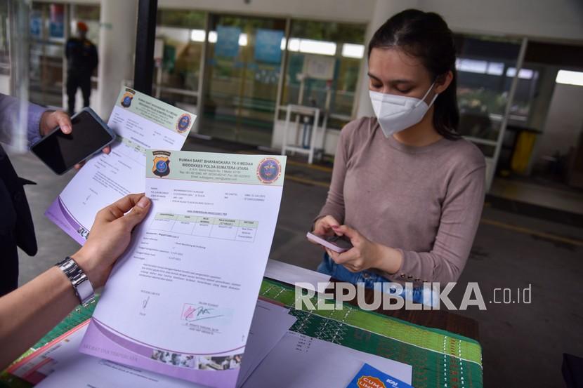 Petugas melayani warga untuk pengecekan dokumen surat keterangan bebas COVID-19 di Stasiun Kereta Api Medan, Kota Medan, Sumatera Utara, Senin (12/7/2021). Selama masa Pemberlakuan Pembatasan Kegiatan Masyarakat (PPKM) Darurat di Kota Medan, PT Kereta Api Indonesia (KAI) Divre I Sumut mewajibkan penumpang antarkota untuk menunjukkan kartu vaksinasi dan surat keterangan hasil negatif tes usap RT-PCR maksimal 2x24 jam atau Rapid Test Antigen maksimal 1x24 jam sebelum keberangkatan demi meredam penyebaran virus COVID-19.