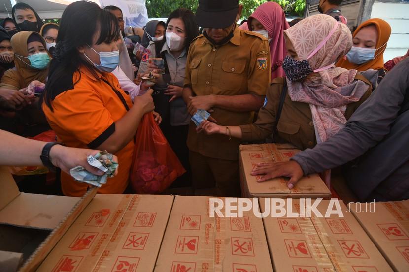 Petugas melayani warga yang membeli minyak goreng di operasi pasar murah, ilustrasi