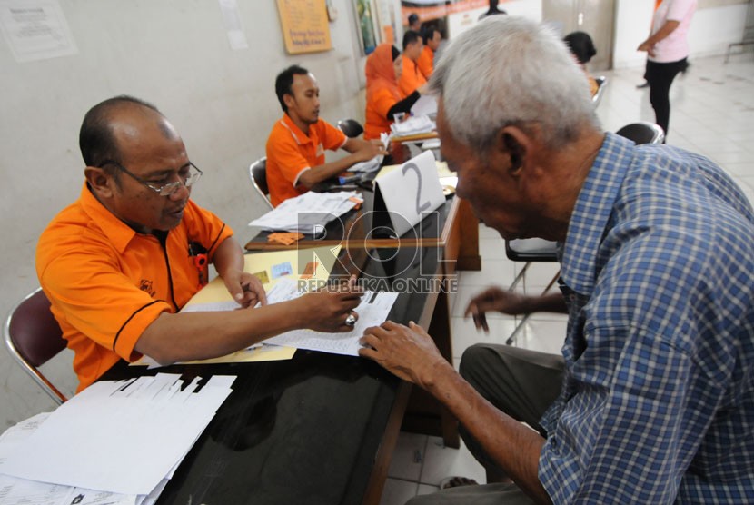   Petugas melayani warga yang mengambil uang Bantuan Langsung Sementara Masyarakat (BLSM) di Jakarta, Sabtu (22/6).  (Republika/Aditya Pradana Putra)