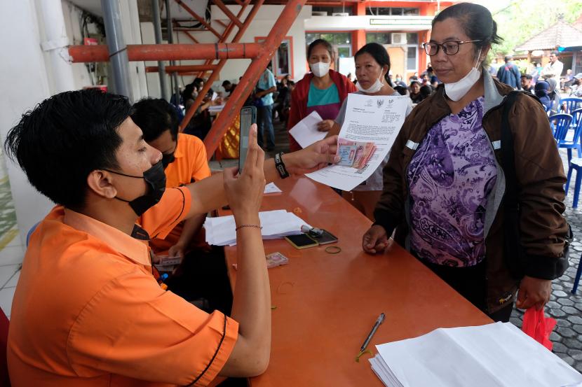 Petugas melayani warga yang mengurus pencairan bantuan langsung tunai (BLT) bahan bakar minyak (BBM) dan bantuan sembako di Kantor Pos Indonesia.
