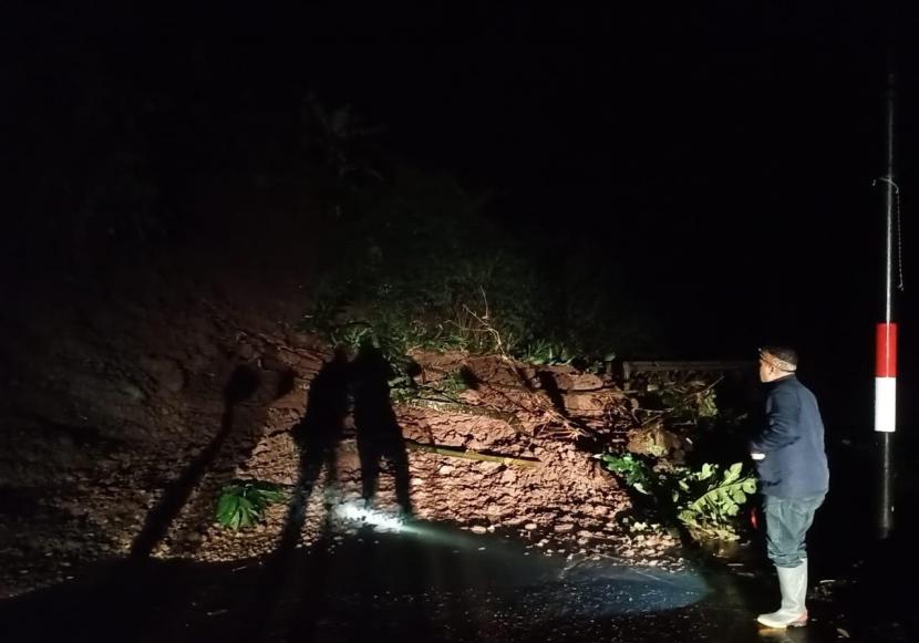 Petugas melihat material longsoran yang menutup jalan provinsi 