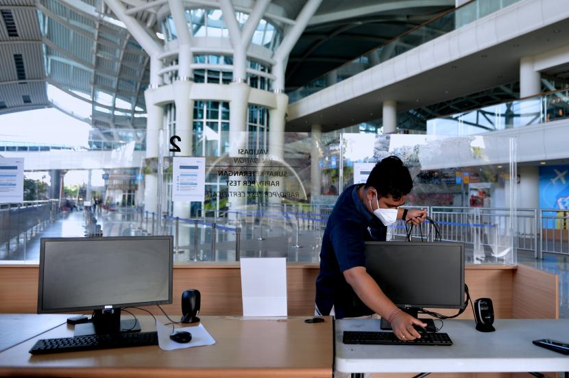 Petugas melintas di area Terminal Internasional menjelang pembukaan kembali penerbangan internasional di Bandara Internasional I Gusti Ngurah Rai, Badung, Bali, Rabu (13/10/2021). Bandara Ngurah Rai akan dibuka kembali untuk melayani penerbangan internasional pada Kamis (14/10) besok.