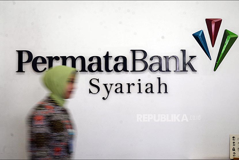 Petugas melintas di depan logo Permata Bank Syariah.