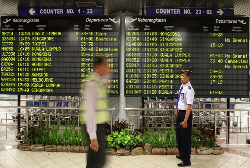  Petugas melintas di depan papan pemberitahuan keberangkatan pesawat di Bandara Ngurah Rai, Denpasar, Bali (ilustrasi) 