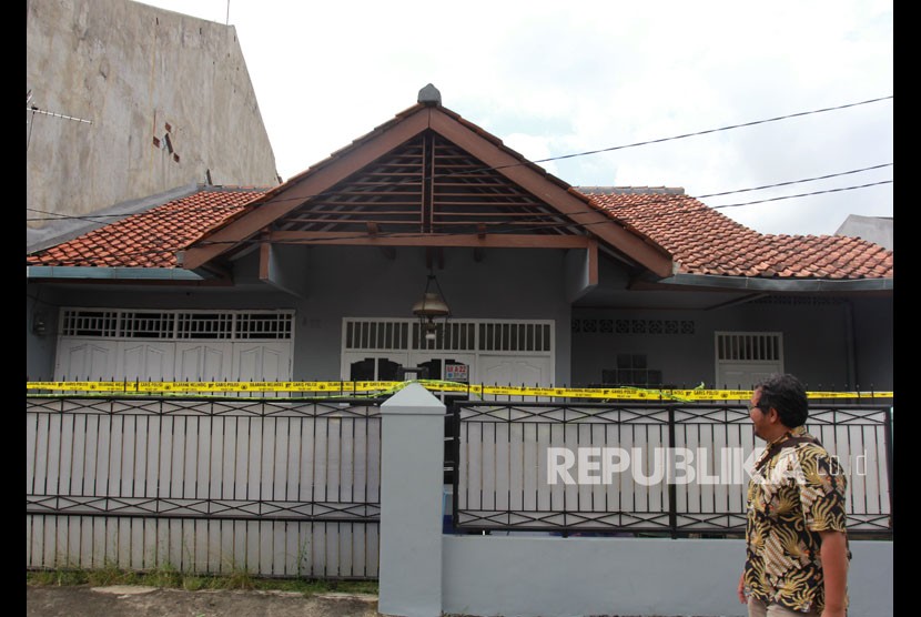 Petugas melintas di depan rumah tempat ditemukan dugaan limbah zat radioaktif di Kompleks Batan Indah Blok A, Serpong, Tangerang Selatan, Banten, Senin (24/2/2020).