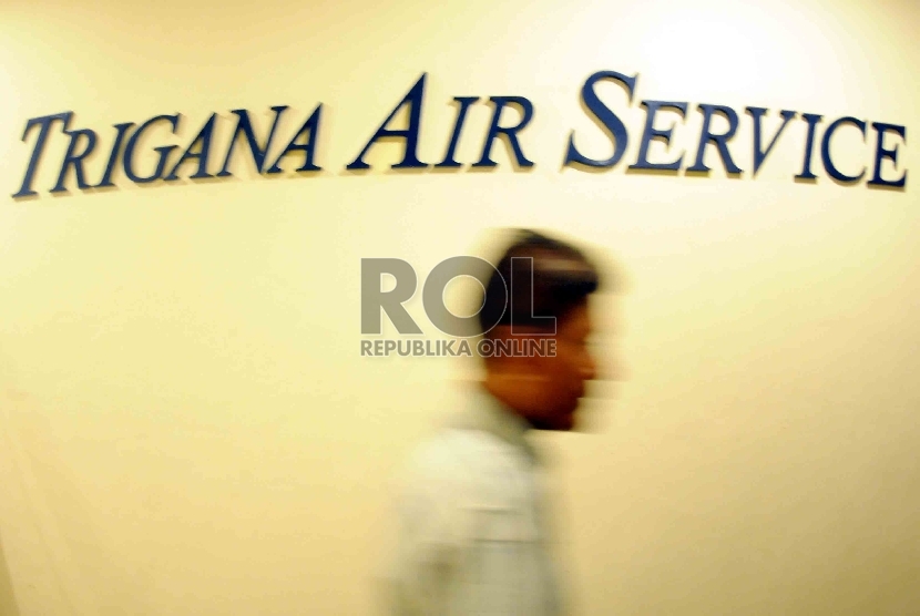 Petugas melintas di kantor maskapai Trigana Air Service di Kompleks Puri Sentana Niaga, Kalimalang, Jakarta, Ahad (16/8).