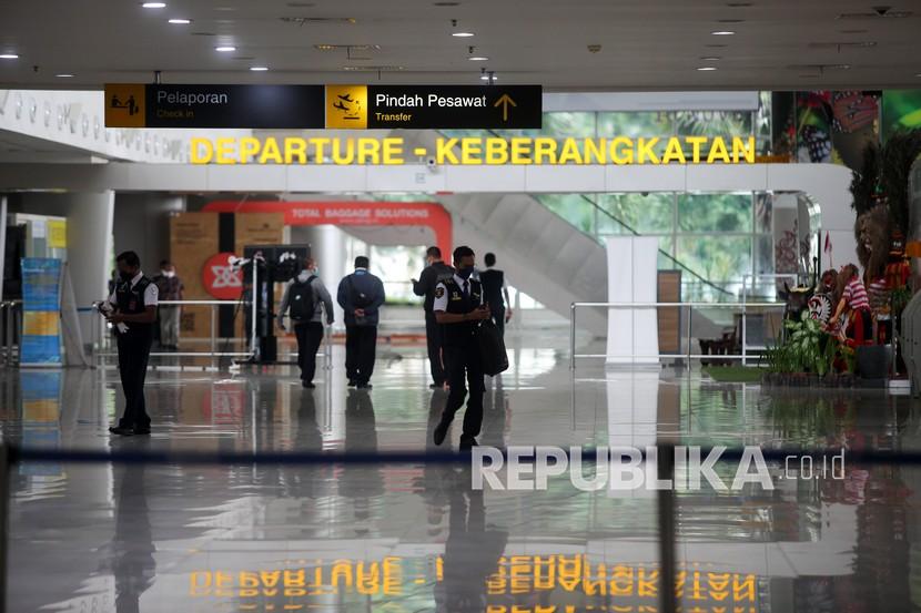 Petugas melintas di keberangkatan Terminal 2 Bandara Internasional Juanda Surabaya di Sidoarjo, Jawa Timur, Jumat (31/12/2021).