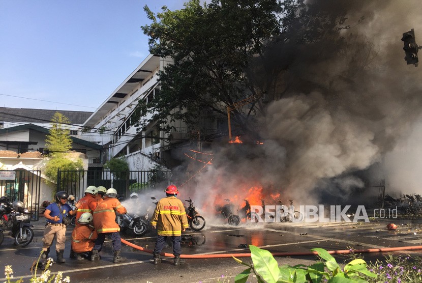 Petugas memadamkan api yang membakar sejumlah sepeda sesaat setelah terjadi ledakan di Gereja Pantekosta Pusat Surabaya (GPPS), Surabaya, Jawa Timur, Ahad (13/5). 