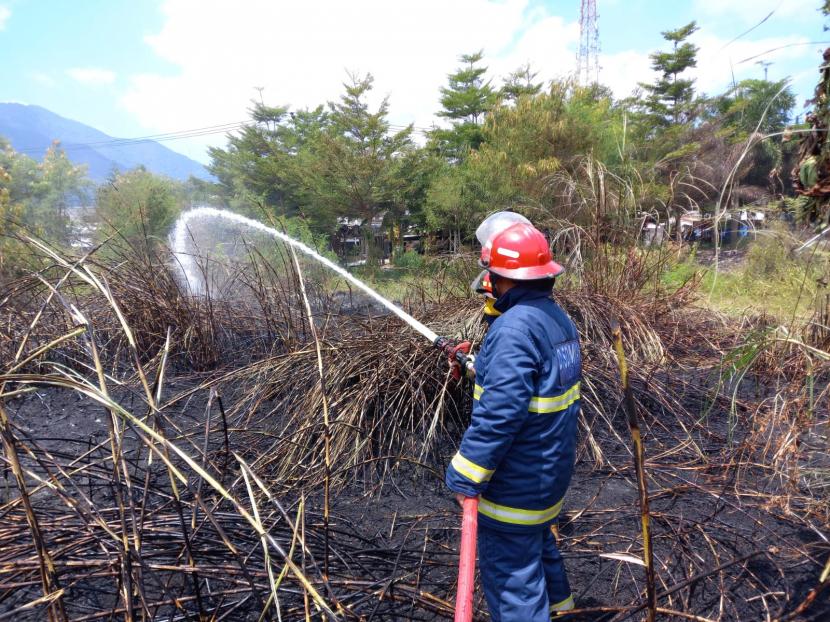 Petugas memadamkan kebakaran api di atas lahan kering di Kampung Kaum, Desa Keresek, Kecamatan Cibatu, Kabupaten Garut, Rabu (25/8). 