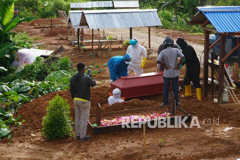 Petugas memakamkan jenazah pasien COVID-19 di pemakaman khusus COVID-19 di Kota Sorong, 
