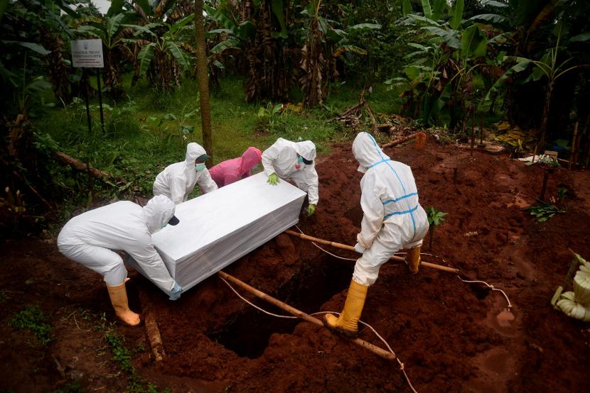 Petugas memakamkan jenazah pasien positif COVID-19 di lokasi pemakaman COVID-19 TPU Pasir Putih, Depok, Jawa Barat.