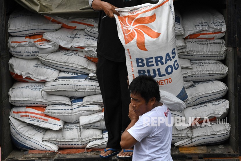 Petugas memanggul karung berisi beras (ilustrasi).