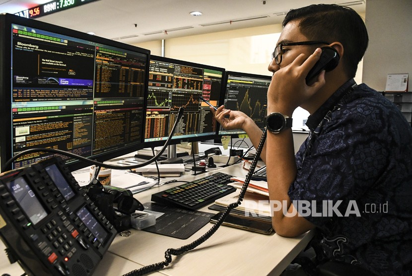 Petugas memantau grafik pergerakan penjualan Indeks Harga Saham Gabungan (IHSG) di Dealing Room Divisi Tresuri BNI, Jakarta, Jumat (27/9/2019).