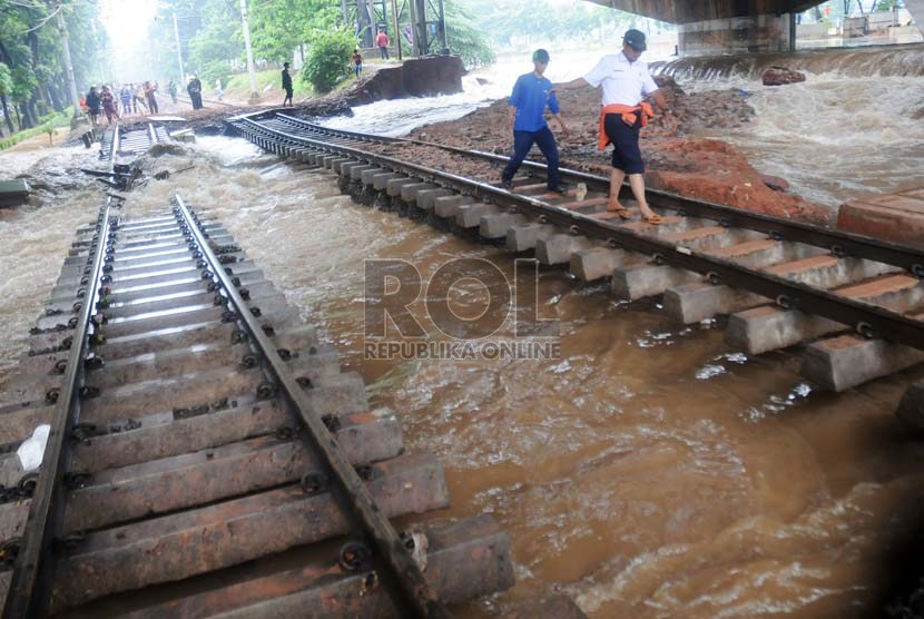  Petugas memantau rel kereta api yang terputus akibat luapan Kanal Banjir Barat di kawasan Taman Lawang, Menteng, Jakarta Pusat, Kamis (17/1).  (Republika/Aditya Pradana Putra)