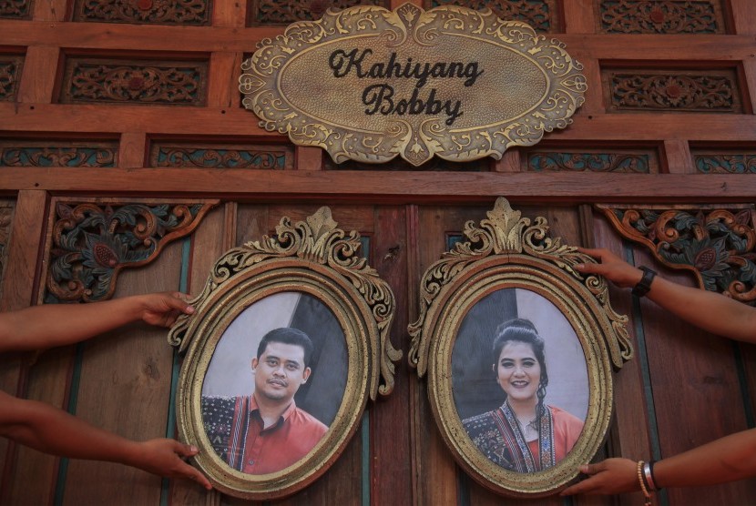 Petugas memasang foto putri Presiden Joko Widodo, Kahiyang Ayu (kanan) dengan Bobby Nasution (kiri) saat menyelesaikan dekorasi pernikahannya di Gedung Graha Saba, Solo, Jawa Tengah, Senin (6/11).