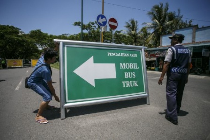 Petugas memasang rambu pengalihan arus di jalan Daendels di Temon, Kulonprogo, DI Yogyakarta, Senin (26/3). Penutupan jalan Daendels tersebut untuk mendukung kapasitas jalan yang akan digunakan untuk lalu lintas kendaraan pembawa material proyek pembangunan New Yogyakarta International Airport di Kulonprogo. 