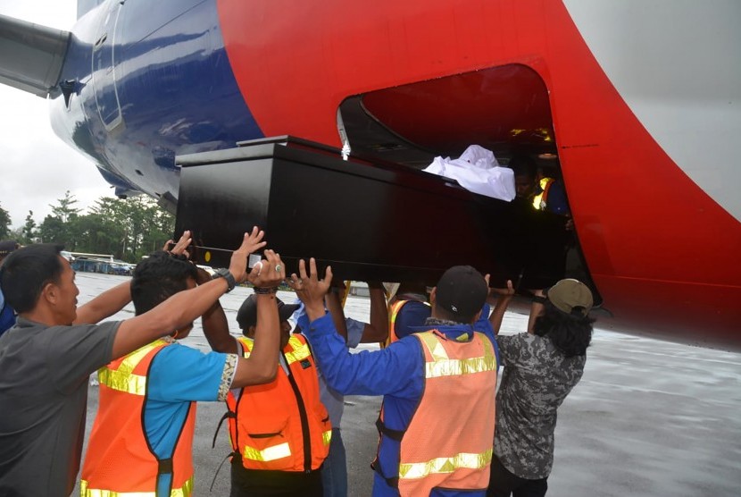 Petugas memasukkan peti berisi jenazah prajurit Kopassus Sersan Satu Anumerta Yusdin ke dalam pesawat untuk diterbangkan ke Makasar di Bandara Mozes Kilangin, Timika, Papua, Jumat (8/3/2019).