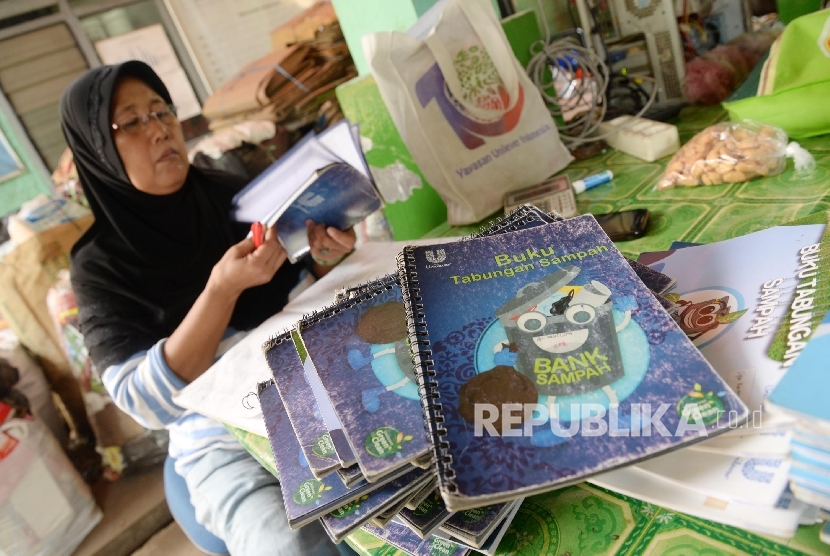 Petugas membaca buku tabungan sampah di Bank Sampah RW. 03 Malaka Sari, Jakarta Timur, Rabu (10/8). (Republika/ Yasin Habibi)