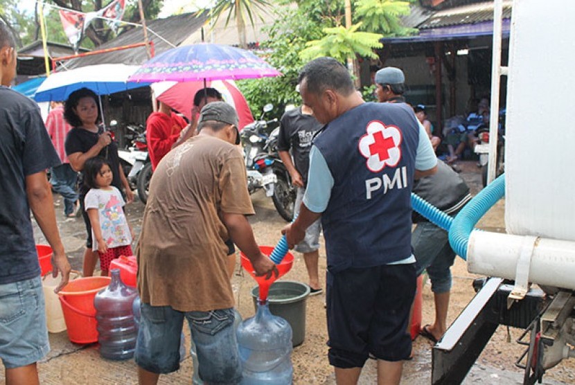 Petugas membagikan air bersih kepada warga Kapuk Muara, Jakarta Utara.