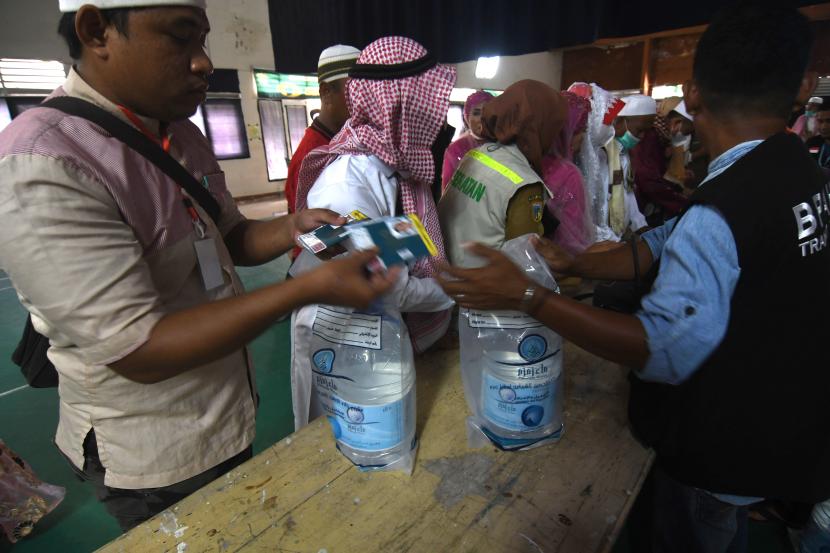 Petugas membagikan air zamzam kepada jamaah haji setibanya di Asrama Haji.