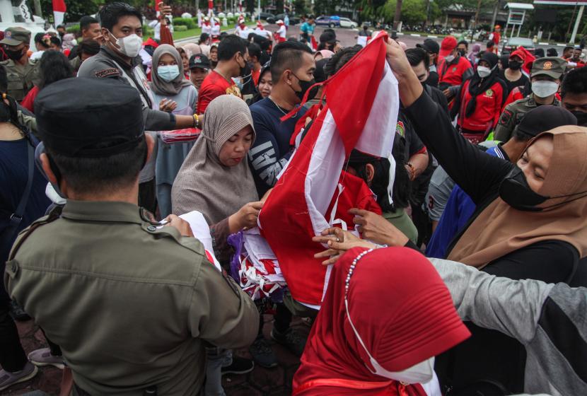 Petugas membagikan bendera Merah Putih kepada warga (ilustrasi)