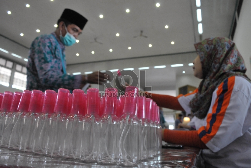 Petugas membagikan botol semprot (Spray) kepada calon jamaah haji di Asrama Haji Pondok Gede, Jakarta, Jumat (28/8).  (Republika/Rakhmawaty La'lang)