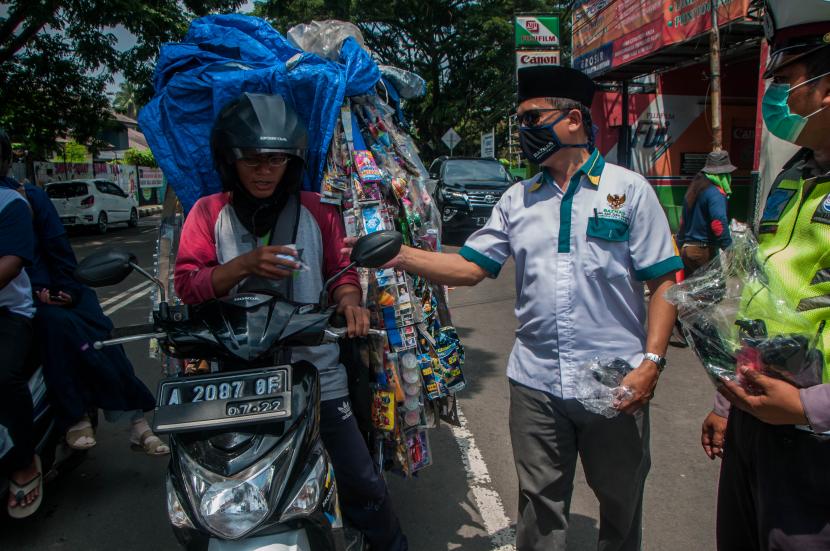 Petugas membagikan masker gratis kepada pedagang keliling, di Rangkasbitung di Lebak, Banten, Senin (13/4/2020). Mulai Agustus 2020, warga Lebak yang tidak bermasker dikenai denda Rp 150 ribu.