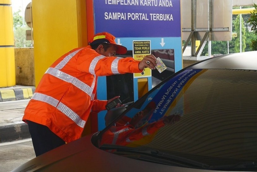 Petugas membagikan uang elektronik kepada penguna jalan, di gerbang tol Banyumanik, Semarang, Selasa (17/10). 