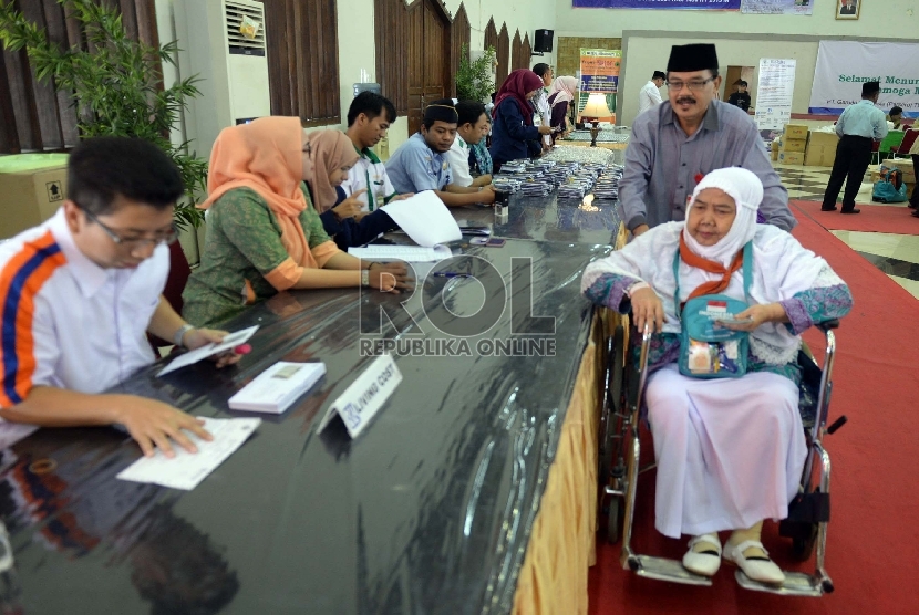 Petugas membanti jamaah calon haji lanjut usia Kloter 31 asal DKI Jakarta memasuki Asrama Haji Pondok Gede, Jakarta, Kamis (10/9). 