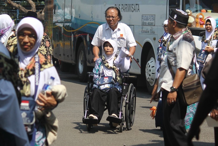 Petugas membantu jamaah calon haji kelompok terbang (kloter) 2 dari Kabupaten Bondowoso tiba di Asrama Haji Embarkasi Surabaya (AHES), Surabaya, Jawa Timur, Senin (16/7)