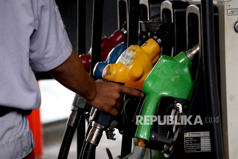  Petugas membantu konsumen mengisi Bahan Bakar Minyak (BBM) pada kendaraan di SPBU Abdul Muis, Jakarta, Ahad (1/10). 