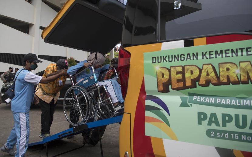 Petugas membantu kontingen menuruni kendaraan sebelum mengikuti Upacara Pembukaan Peparnas Papua di Stadion Mandala Jayapura, Papua.