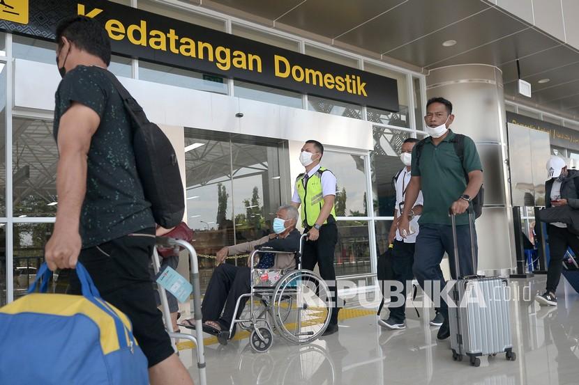 Petugas membantu salah satu penumpang yang tiba di Bandara Internasional Sam Ratulangi, Manado, Sulawesi Utara, Senin (11/4/2022). 