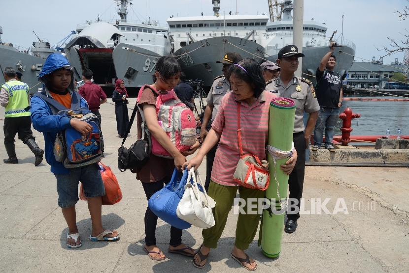 Petugas membantu warga eks anggota Gerakan Fajar Nusantara (Gafatar) yang baru turun dari KRI Banten saat tiba di Pelabuhan Kolinlamil Tanjung Priok, Jakarta Utara, Rabu (27/1).  (Republika/Yasin Habibi)