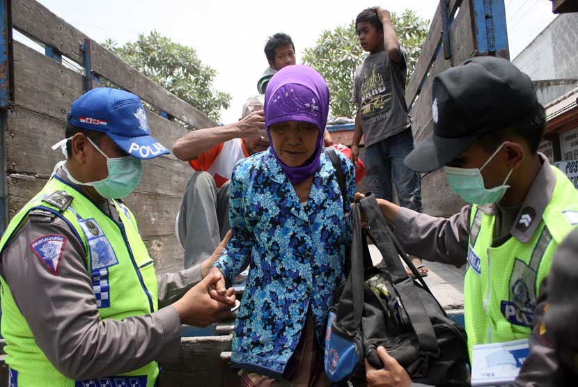  Petugas membantu warga korban erupsi Gunung Kelud turun dari truk ketika mengungsi di Balai Desa Tawang, Kecamatan Wates, Kediri, Jawa Timur, Jumat (14/2). 