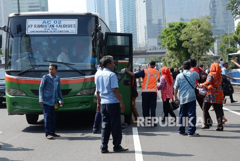 Petugas membantu warga mencarikan angkutan umum pengganti saat sopir taksi melakukan sweeping di Jalan Gatot Soebroto, Jakarta, Selasa (22/3). (Republika/Yasin Habibi)