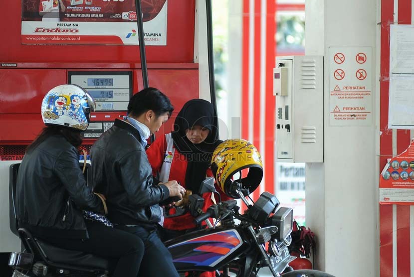 Petugas membantu warga mengisi bahan bakar minyak (BBM) jenis premium di SPBU Jakarta,Selasa (23/9).(Republika/Prayogi)