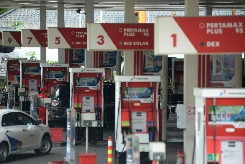  Petugas membantu warga mengisi bahan bakar minyak Premium di SPBU di Jakarta, Ahad (1/3).