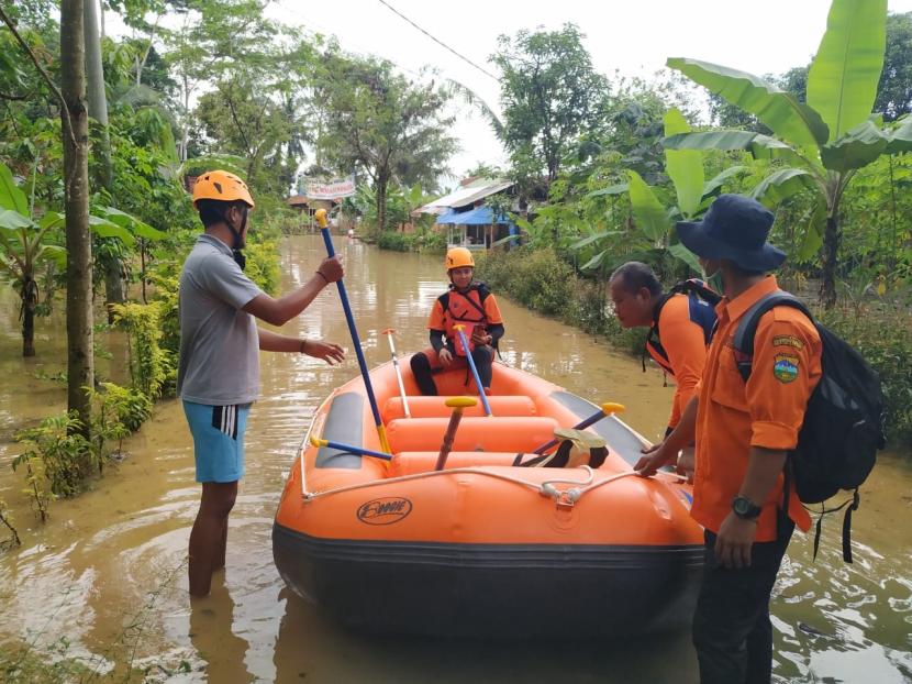 Petugas membantu warga terdampak banjir di Desa Tanjungsar, Kecamatan Sukaresik, Kabupaten Tasikmalaya, untuk melakukan evakuasi, Jumat (19/6).
