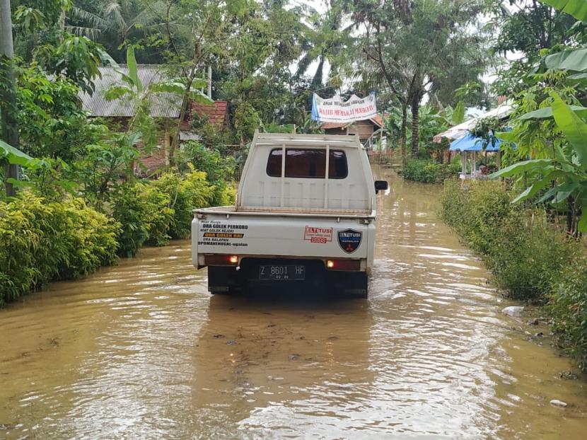 Petugas membantu warga terdampak banjir di Desa Tanjungsar, Kecamatan Sukaresik, Kabupaten Tasikmalaya, untuk melakukan evakuasi, Jumat (19/6).