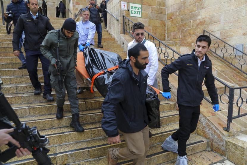 Petugas membawa jenazah warga Palestina yang tewas tertembak di Yerusalem, Ahad (21/11).