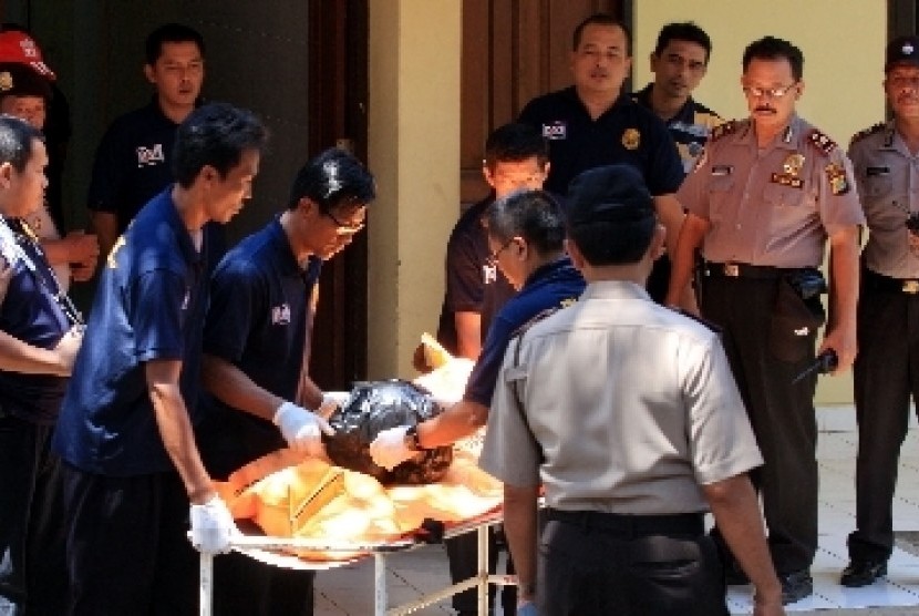 Petugas membawa kantong jenazah terduga teroris Solo di Rumah Sakit Polri Kramat Jati, Jakarta, Sabtu (1/9). 