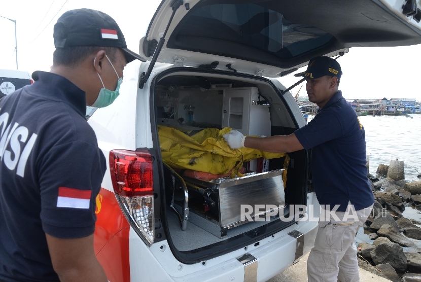 Petugas membawa korban yang terbakar di dalam kapal motor Zahro Express di dermaga Muara Angke, Jakarta, Ahad (1/1).Republika/Yasin Habibi